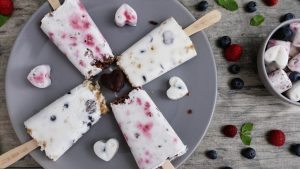 Zweierlei Kokos-Popsicles mit Beeren, Schoko-Crossies und Macadamiakrokant