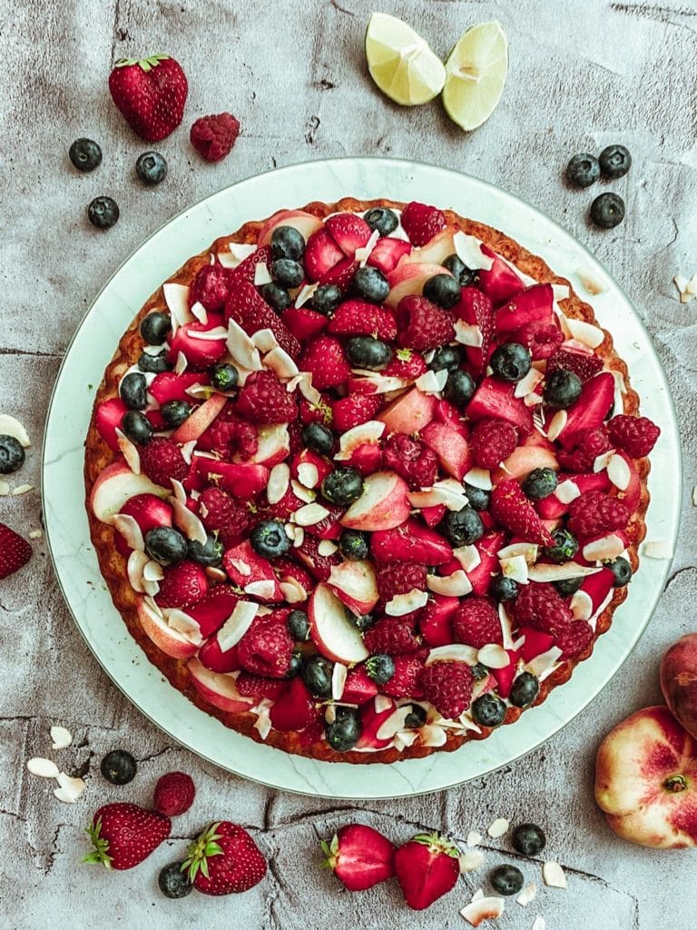 Zuckerfreier Mandelbiskuit mit Kokoscreme, Beeren und Plattpfirsichen
