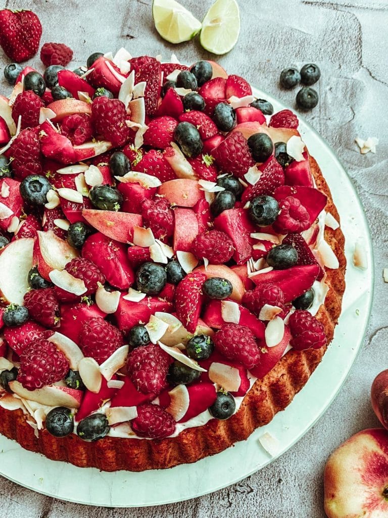 Zuckerfreier Mandelbiskuit mit Kokoscreme, Beeren und Plattpfirsichen