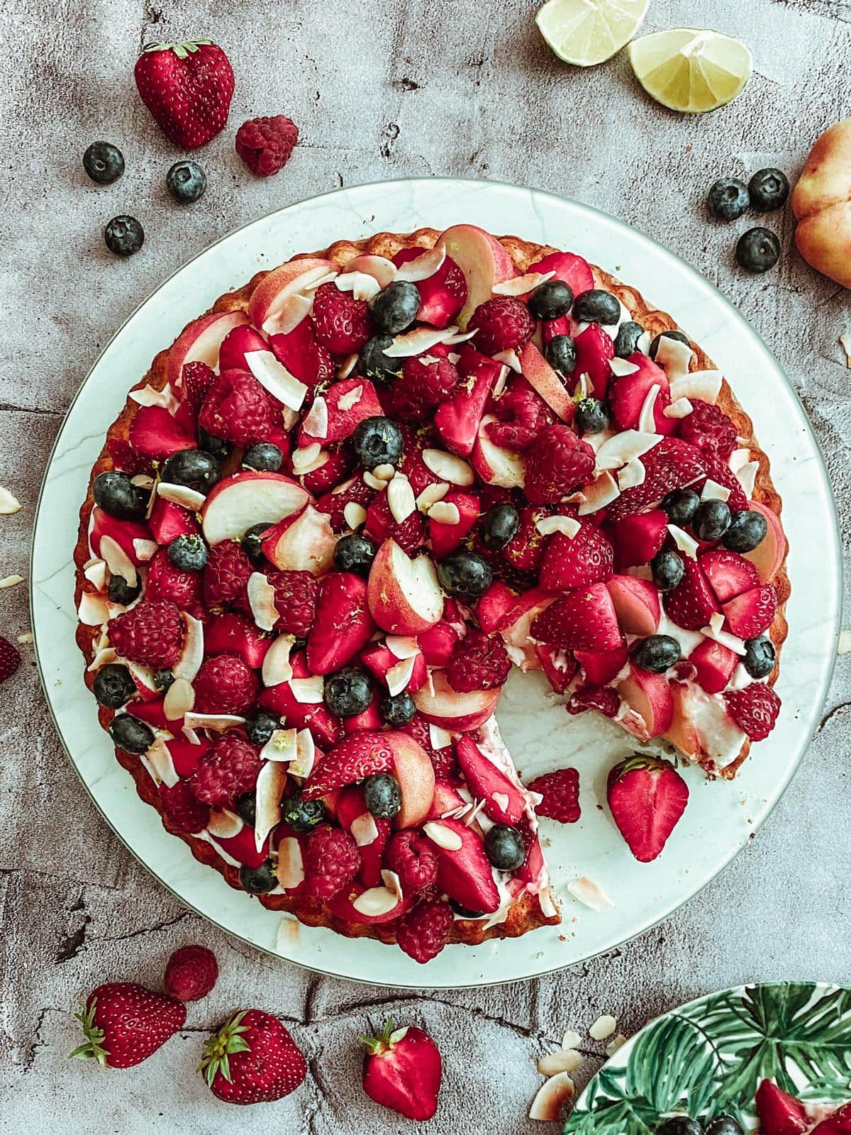 Zuckerfreier Mandelbiskuit mit Kokoscreme, Beeren und Plattpfirsichen