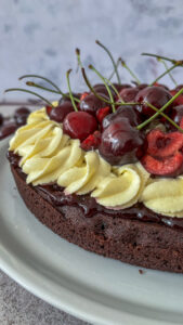 Einfacher Schokokuchen mit Vanillecreme und frischen Kirschen