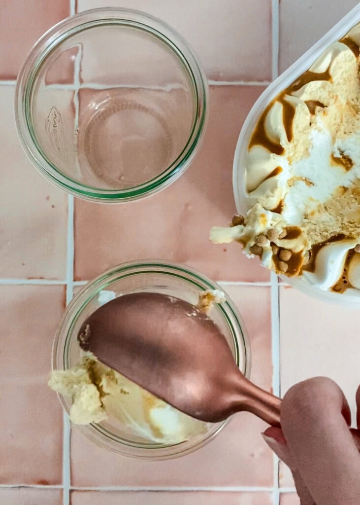 Zwei Gläser, ein Eisportionierer in roségold und Salted Caramel Eiscreme